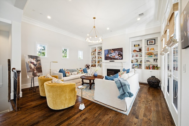 living room featuring ornamental molding, dark hardwood / wood-style floors, built in features, and an inviting chandelier