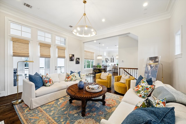 living room with crown molding, hardwood / wood-style floors, and a chandelier