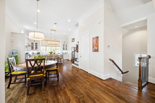 dining area featuring a towering ceiling, crown molding, dark hardwood / wood-style floors, and plenty of natural light