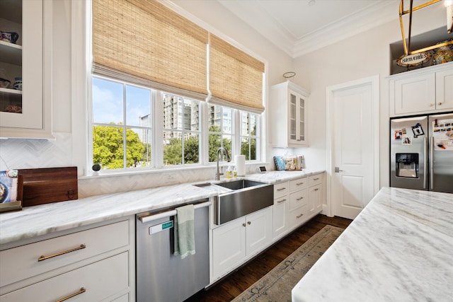 kitchen with light stone countertops, stainless steel appliances, dark wood-type flooring, sink, and white cabinetry