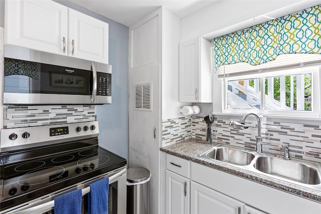 kitchen featuring stainless steel appliances, white cabinetry, and sink