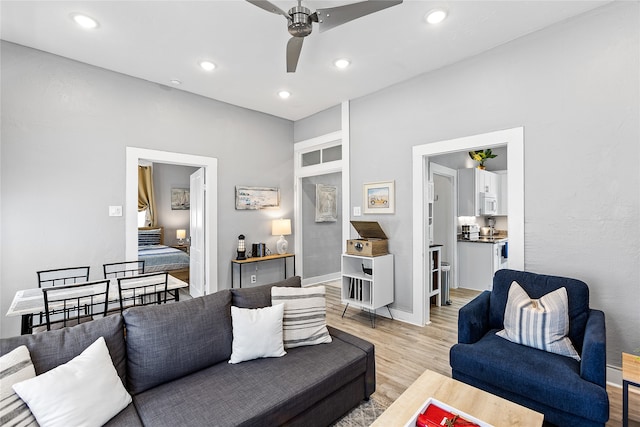 living room with light wood-type flooring and ceiling fan