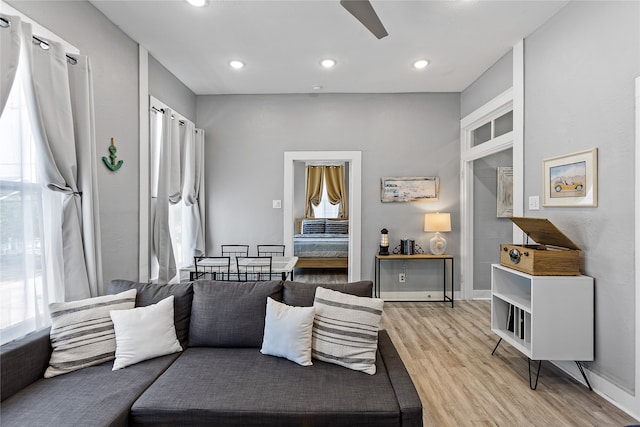 living room featuring light hardwood / wood-style flooring and ceiling fan