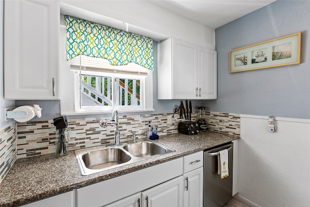 kitchen featuring tasteful backsplash, white cabinetry, sink, and stainless steel dishwasher