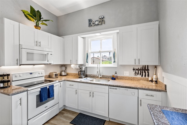 kitchen featuring light wood-type flooring, white appliances, sink, and white cabinets