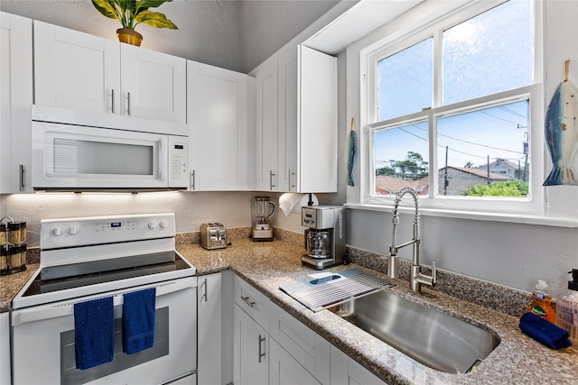 kitchen with white cabinets, sink, and white appliances