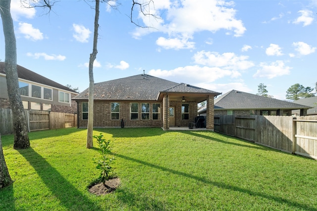 back of house with a patio area and a yard