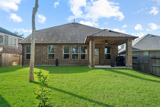 back of property with a lawn, ceiling fan, and a patio area