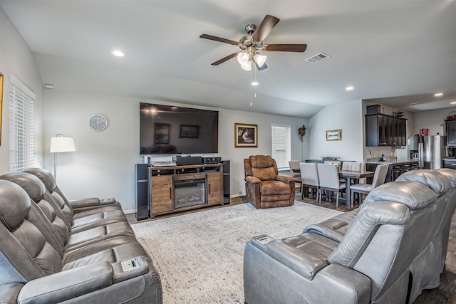 living room with vaulted ceiling, ceiling fan, and wood-type flooring