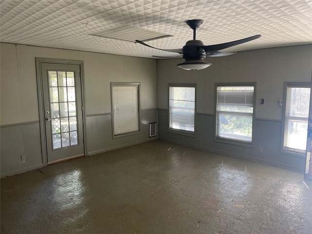 unfurnished room featuring a wealth of natural light and ceiling fan