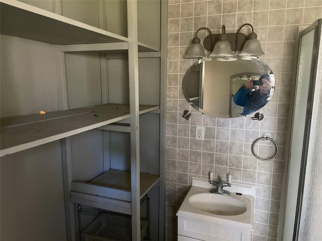 bathroom featuring tasteful backsplash, vanity, and tile walls