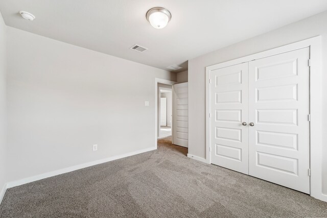 unfurnished bedroom featuring carpet and a closet