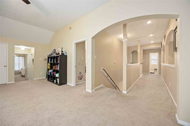 corridor featuring light carpet and vaulted ceiling