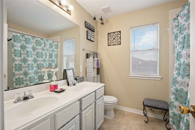 bathroom featuring vanity, tile patterned floors, and toilet