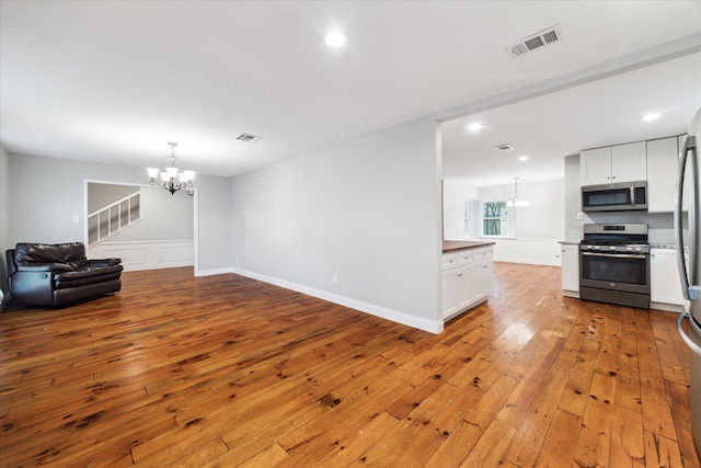 living room with light hardwood / wood-style floors and a notable chandelier