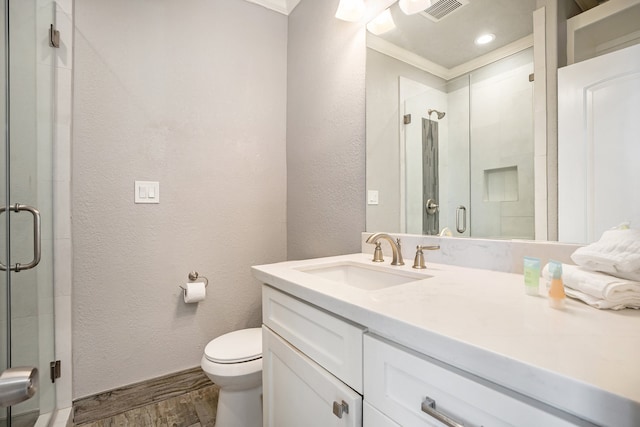 bathroom with vanity, toilet, ornamental molding, walk in shower, and wood-type flooring