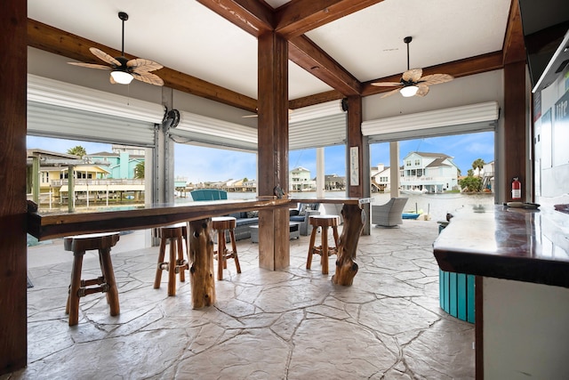 dining area featuring ceiling fan and beamed ceiling