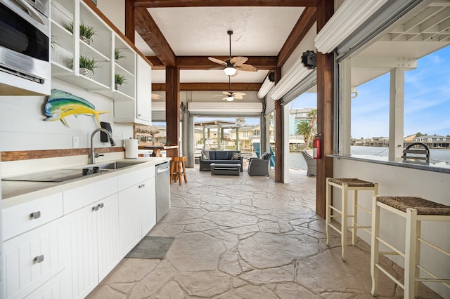 kitchen featuring pendant lighting, white cabinets, sink, stainless steel dishwasher, and ceiling fan