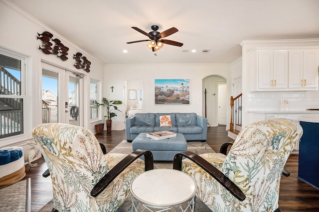 living room with dark hardwood / wood-style floors, ceiling fan, and ornamental molding