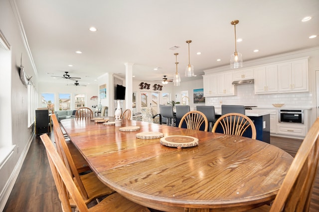 dining room with dark hardwood / wood-style flooring, decorative columns, ceiling fan, and crown molding