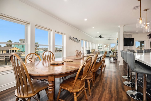 dining space featuring ornate columns, crown molding, ceiling fan, and dark hardwood / wood-style floors