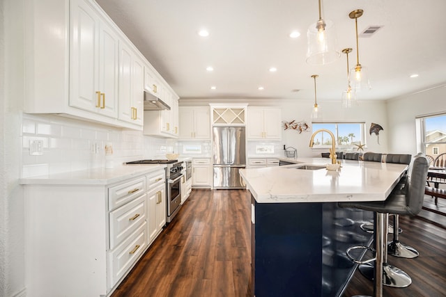 kitchen featuring appliances with stainless steel finishes, a spacious island, sink, white cabinets, and hanging light fixtures