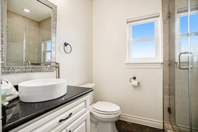 bathroom featuring tile patterned floors, a shower with door, vanity, and toilet