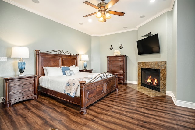 bedroom with ceiling fan, dark hardwood / wood-style floors, crown molding, and a tiled fireplace