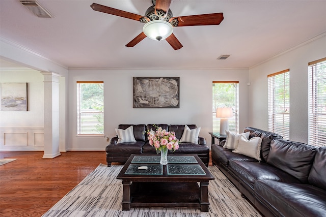 living room featuring wood-type flooring, plenty of natural light, and decorative columns