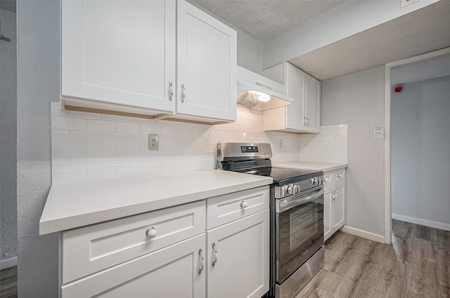 kitchen with stainless steel stove, extractor fan, and white cabinetry