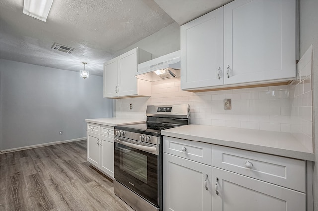 kitchen featuring white cabinets, stainless steel stove, light hardwood / wood-style flooring, and decorative backsplash