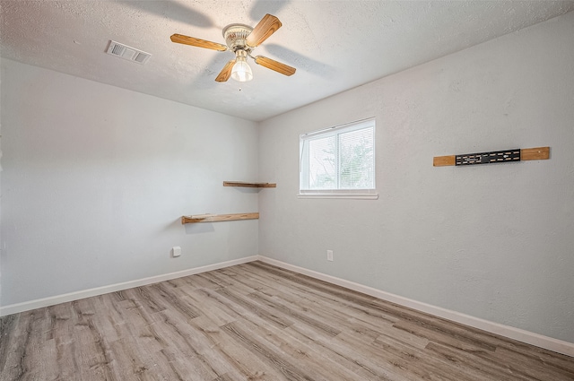 spare room with light hardwood / wood-style floors, ceiling fan, and a textured ceiling