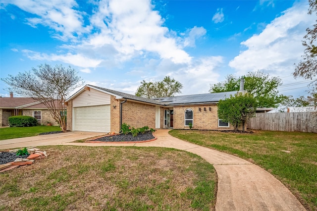 single story home featuring a garage, solar panels, and a front yard