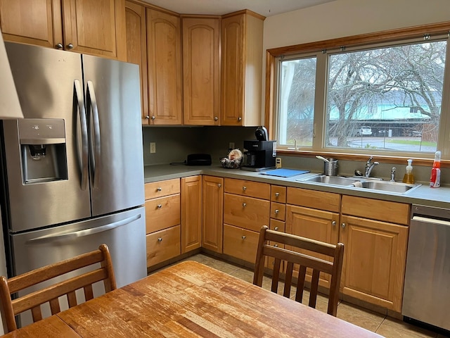 kitchen featuring light tile patterned flooring, stainless steel appliances, and sink