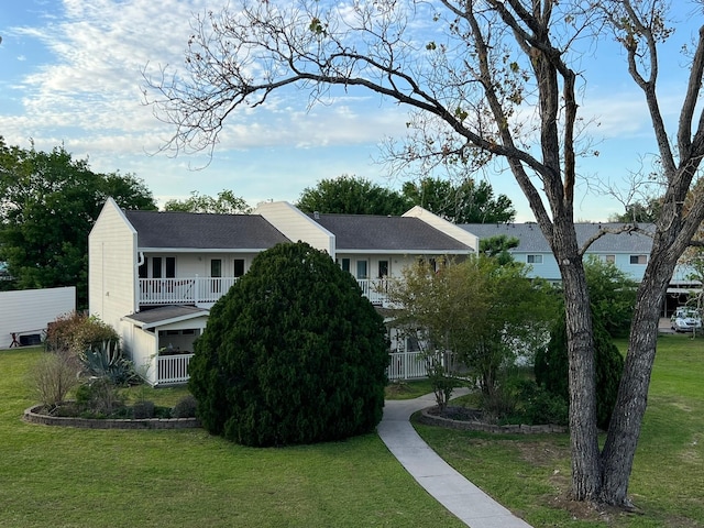 exterior space with a balcony and a front lawn