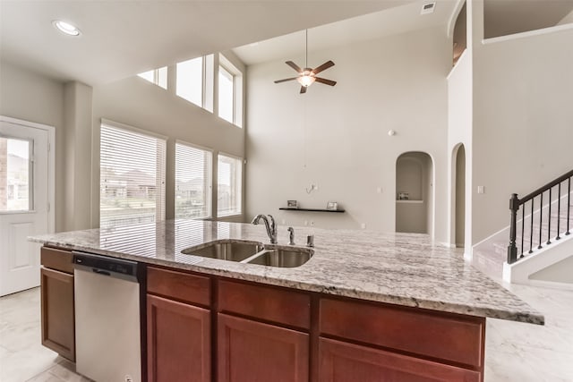 kitchen featuring a healthy amount of sunlight, high vaulted ceiling, stainless steel dishwasher, and sink