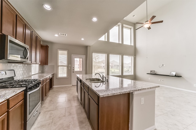 kitchen featuring plenty of natural light, sink, an island with sink, and stainless steel appliances