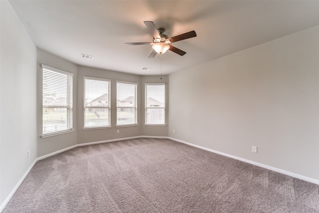 carpeted spare room with ceiling fan