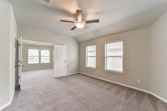 carpeted spare room featuring plenty of natural light, lofted ceiling, and ceiling fan