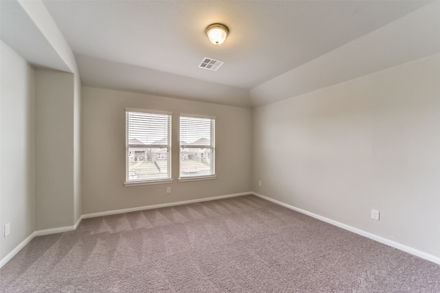 spare room with carpet and lofted ceiling