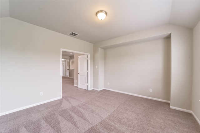 spare room with vaulted ceiling and carpet flooring