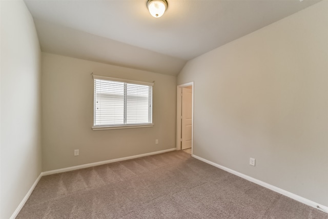 unfurnished room featuring lofted ceiling and carpet floors