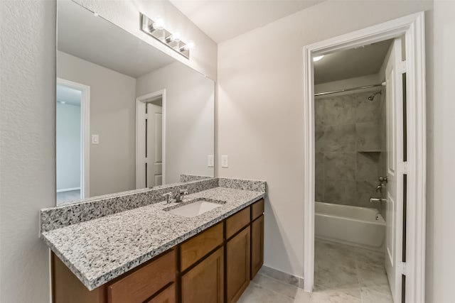 bathroom featuring tiled shower / bath and vanity