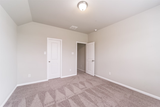 unfurnished bedroom featuring light carpet and vaulted ceiling