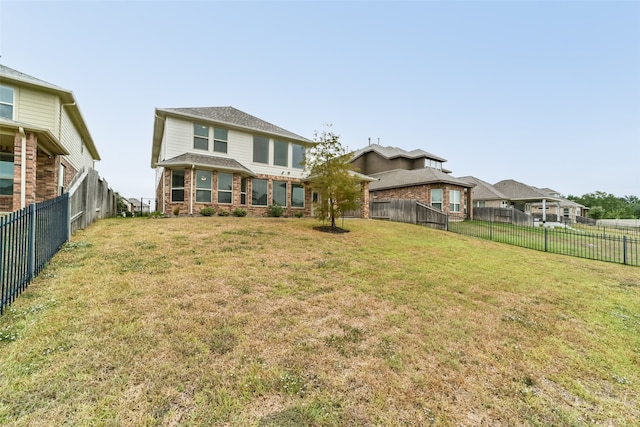 rear view of house featuring a yard