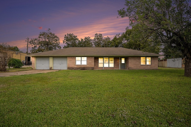 single story home featuring a garage and a yard