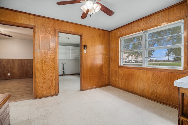 unfurnished bedroom with wood walls and ceiling fan