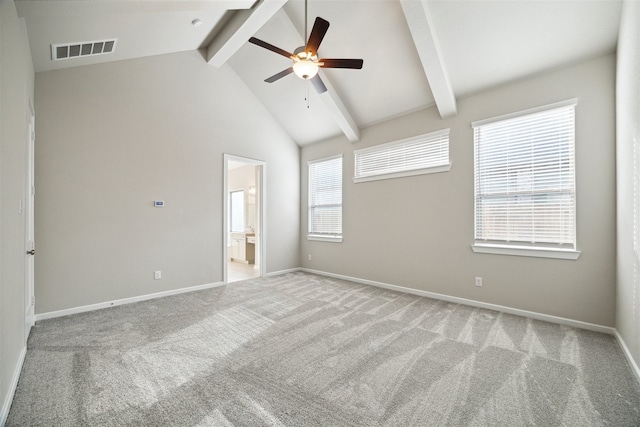 spare room with plenty of natural light, ceiling fan, light colored carpet, and beam ceiling