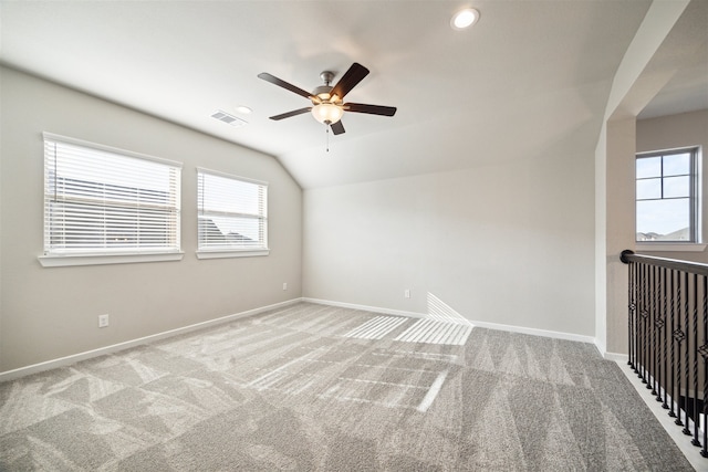 additional living space featuring vaulted ceiling, light carpet, and ceiling fan