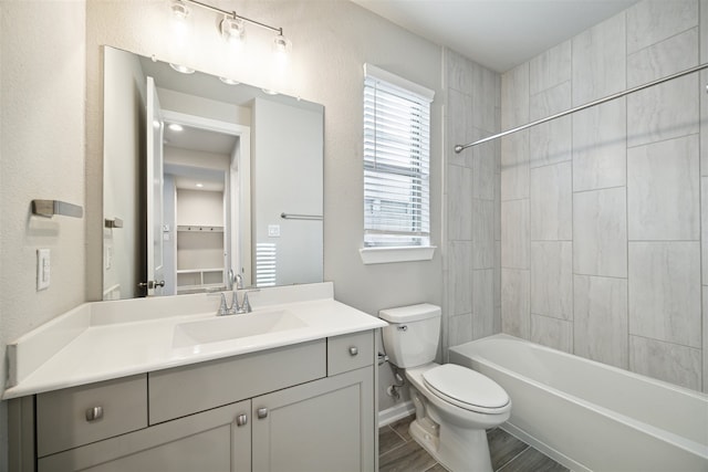 full bathroom featuring toilet, tiled shower / bath combo, and vanity